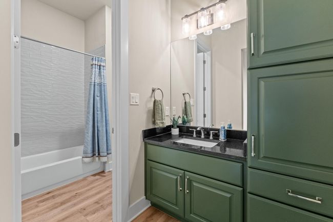 Bathroom featuring baseboards, wood finished floors, vanity, and shower / tub combo with curtain | Image 31