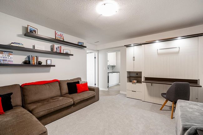 Living area featuring light carpet and a textured ceiling | Image 26