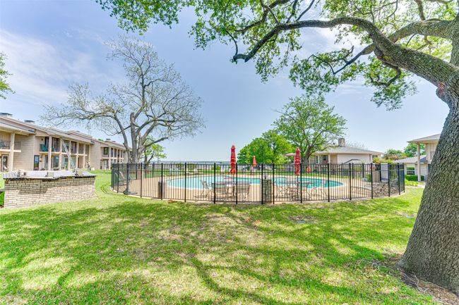 Pool with a patio area, fence, and a lawn | Image 26