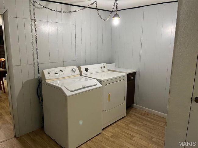 Laundry area featuring washer and clothes dryer, light wood finished floors, and baseboards | Image 15