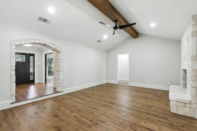 Unfurnished living room featuring wood-type flooring, ceiling fan, arched walkways, and recessed lighting | Image 11