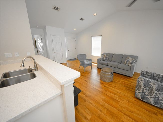 Kitchen featuring a sink, lofted ceiling, light wood-type flooring, and visible vents | Image 15