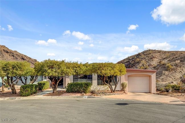 View of property hidden behind natural elements with driveway, a mountain view, stucco siding, and a garage | Image 4