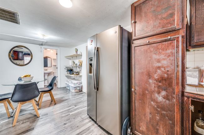 Kitchen featuring stainless steel fridge with ice dispenser and light wood-style flooring | Image 7