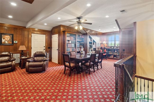 Currently used as a home office and study, the third floor could be a man cave, a game room, or a media center as well. The door on the right is the elevator and the door on the left opens to a walk-in attic. | Image 37
