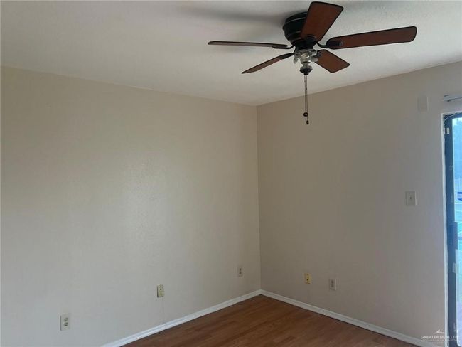 Spare room featuring wood finished floors and a ceiling fan | Image 9