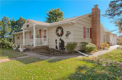 View of front of house with a porch, a garage, and a front lawn | Image 1