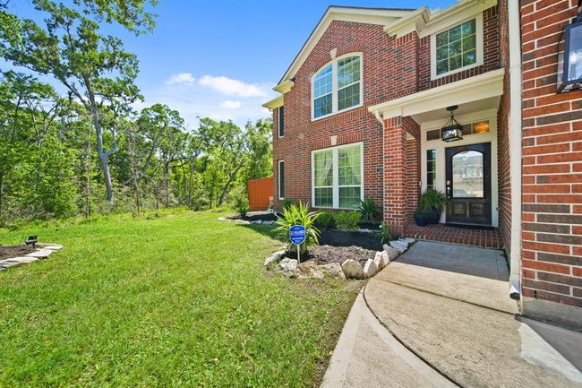 A curved sidewalk leads you to the welcoming covered front porch and elegant glass-panel entry door—setting the tone for the comfort inside. | Image 4