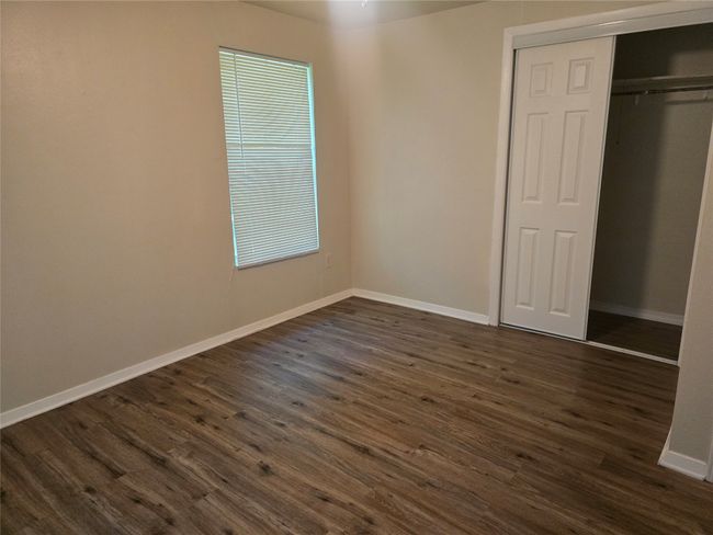 Unfurnished bedroom featuring dark wood finished floors and a closet | Image 14