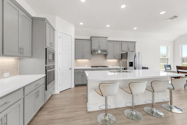 Kitchen with gray cabinetry, appliances with stainless steel finishes, a sink, and under cabinet range hood | Image 9