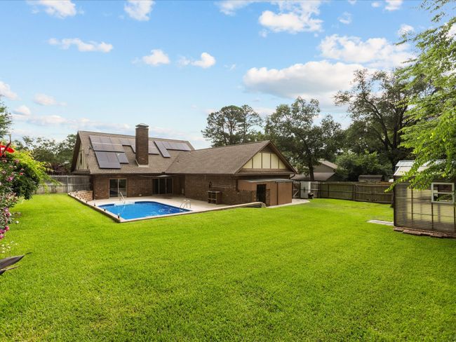Back of property with roof mounted solar panels, brick siding, a chimney, and a patio | Image 6