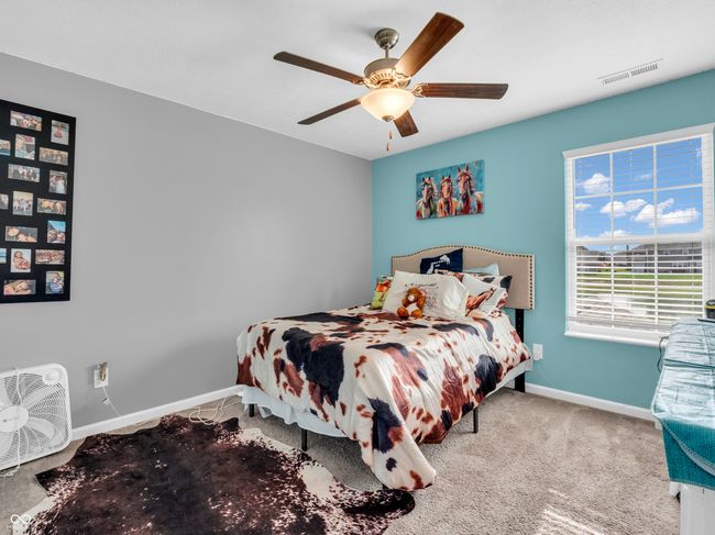 carpeted bedroom with a pleasant color scheme. | Image 30