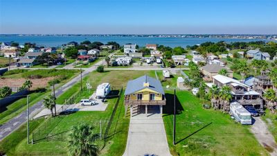 This aerial photo showcases a coastal neighborhood with a mix of single-family homes and RVs, featuring spacious lots and proximity to the water, offering a relaxed, beachside living experience. | Image 3