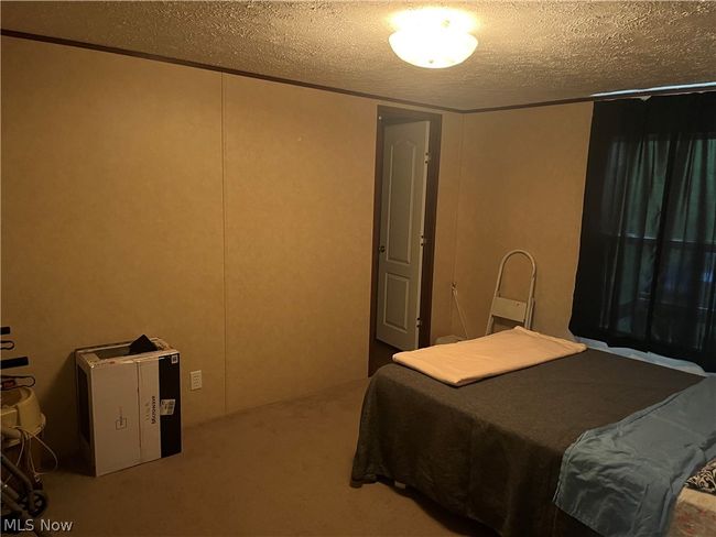 Carpeted bedroom with a textured ceiling | Image 8