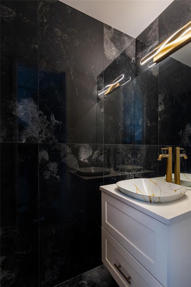 Bathroom with tile walls, vanity, marble finish floors, and walk in shower | Image 17