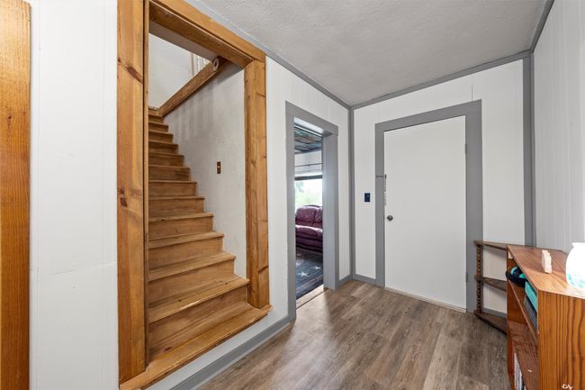 Entryway featuring a textured ceiling, wood finished floors, and stairway | Image 9