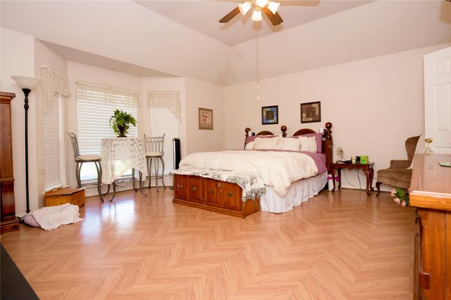 Bedroom with a baseboard radiator, a towering ceiling, and ceiling fan | Image 11
