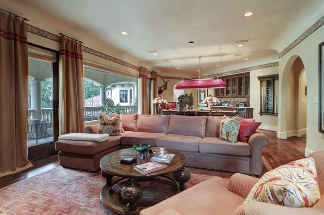 A view of the game room and bar. The bar has copper sink, refrigerator and limestone counters. To the right is a study area, utility room, bedroom with bathroom, elevator and back staircase. | Image 27