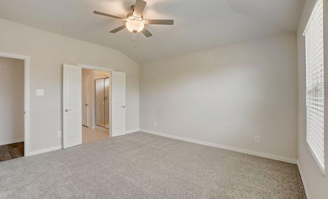 Unfurnished bedroom featuring vaulted ceiling, light colored carpet, and ceiling fan | Image 8