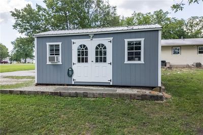 View of outdoor structure featuring cooling unit, central AC, and a yard | Image 3