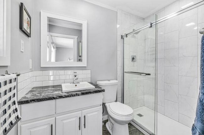 Full bathroom featuring toilet, a stall shower, and vanity | Image 21
