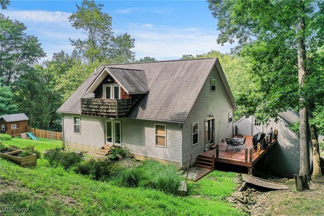 Back of house with roof with shingles, a garden, and view of scattered trees | Image 48