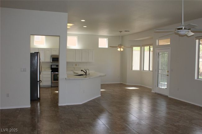 Kitchen with stainless steel appliances, a sink, open floor plan, baseboards, and ceiling fan | Image 14