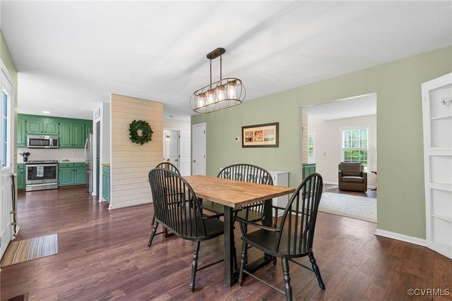 Dining room featuring an inviting chandelier and dark wood-style flooring | Image 19