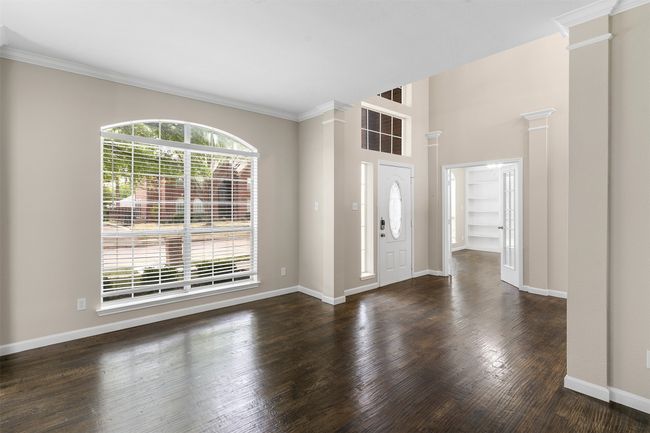 Entryway featuring dark wood-style floors, baseboards, and ornate columns | Image 7