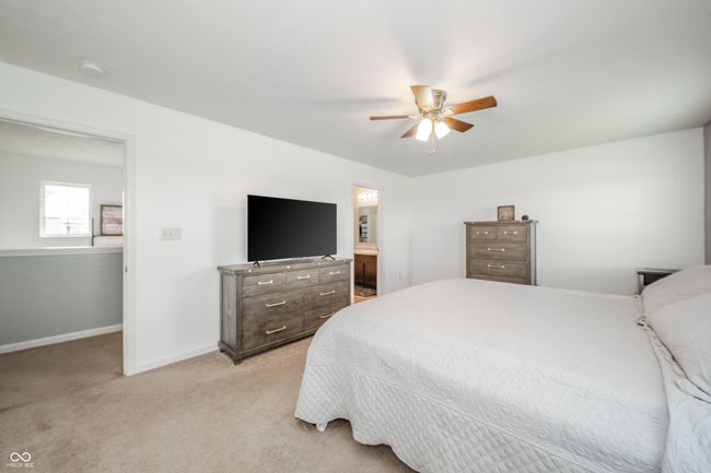 bedroom featuring light colored carpet, baseboards, and a ceiling fan | Image 32