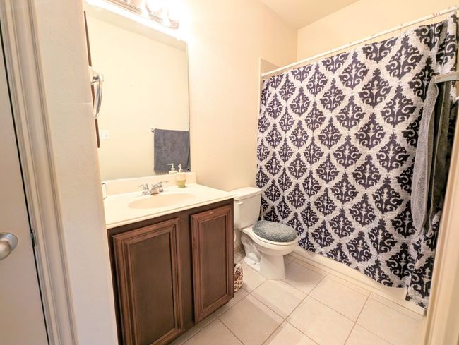 Full bath with tile patterned flooring, vanity, and a shower with shower curtain | Image 11