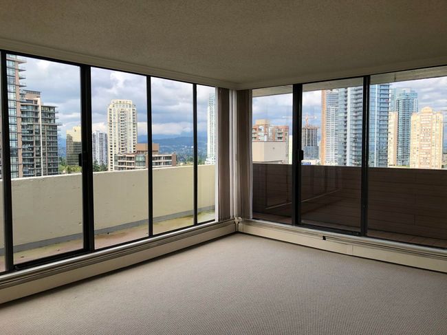 Carpeted empty room featuring a city view, a healthy amount of sunlight, and a textured ceiling | Image 12