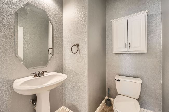 Half bath with baseboards, a textured wall, and toilet | Image 18