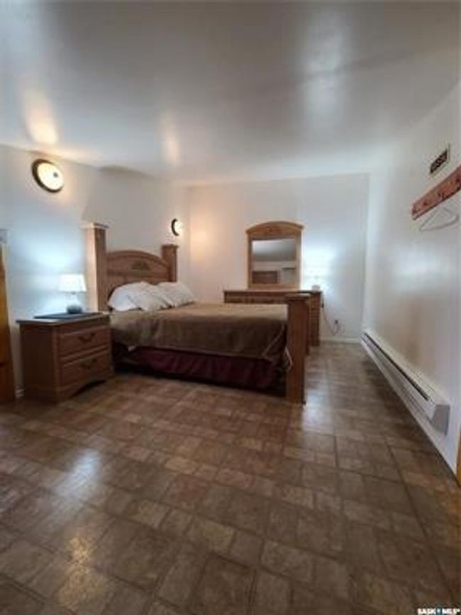 Bedroom featuring a baseboard heating unit and dark tile patterned flooring | Image 31