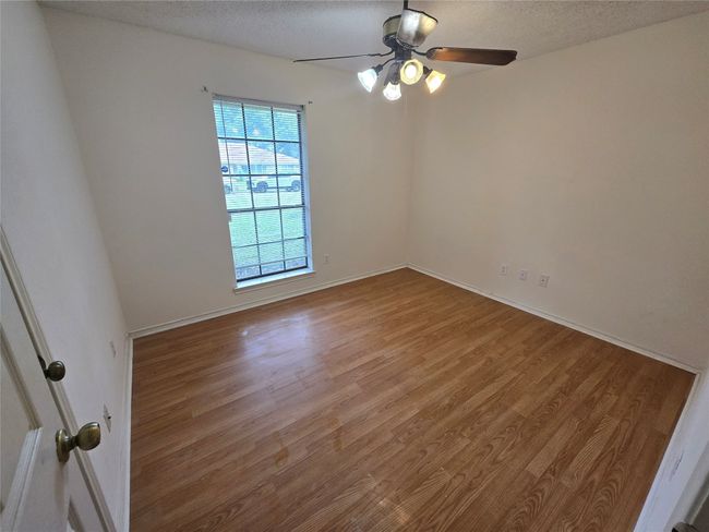 Spare room featuring wood finished floors, a ceiling fan, and a textured ceiling | Image 19