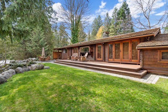 Back of house with a chimney, a deck, and a lawn | Image 21