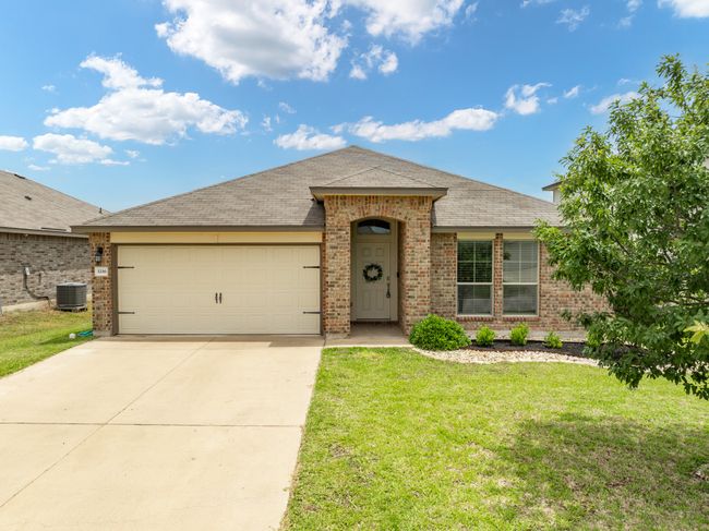Single story home with brick siding, concrete driveway, a front yard, an attached garage, and a shingled roof | Image 25