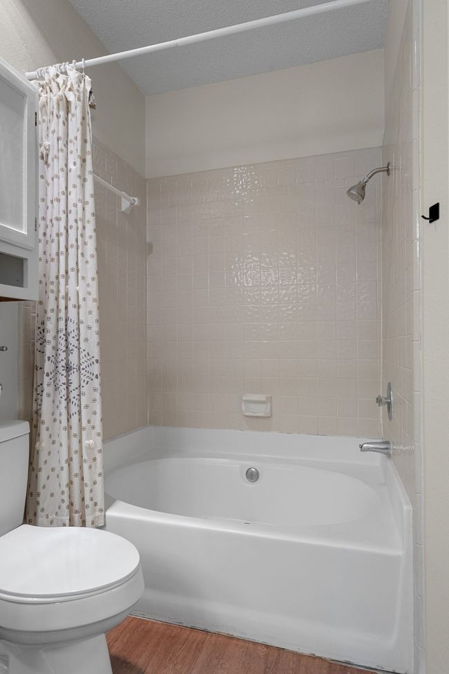 Full bath with wood finished floors and shower / bathtub combination with curtain | Image 17