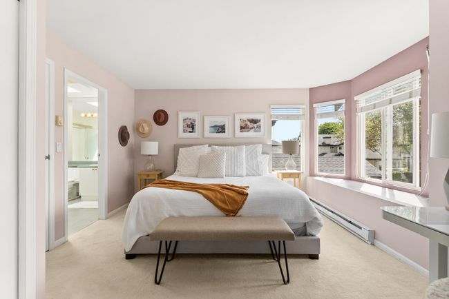 Bedroom with a baseboard heating unit, light colored carpet, baseboards, and ensuite bathroom | Image 21