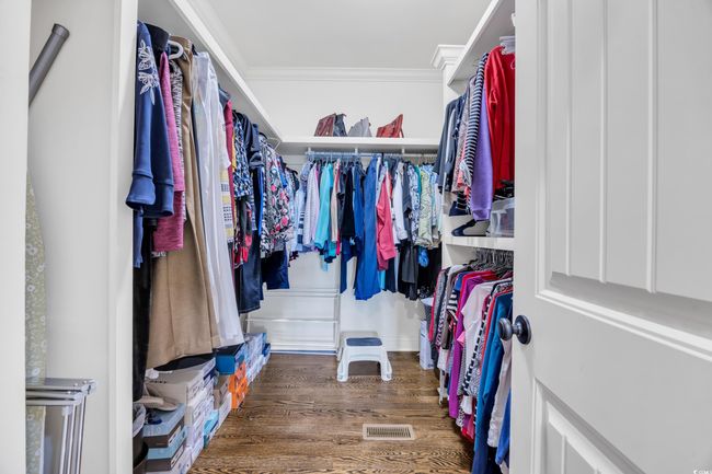 Walk in closet featuring wood finished floors and custom built ins | Image 19