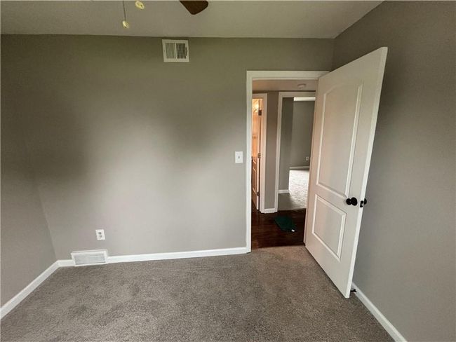Empty room featuring dark colored carpet, visible vents, and baseboards | Image 20