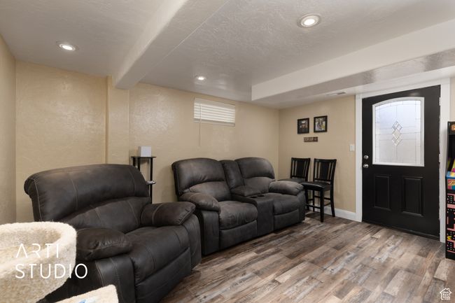 Living room with wood finished floors, a textured wall, recessed lighting, baseboards, and beamed ceiling | Image 50