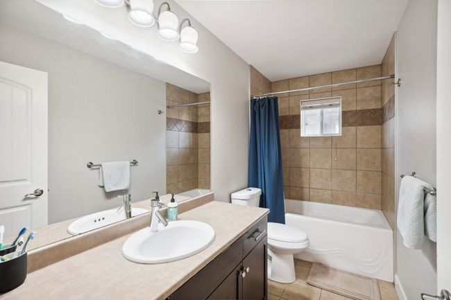 Bathroom featuring tile patterned floors, shower / bath combo with shower curtain, vanity, and toilet | Image 27