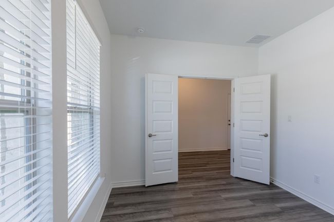 Unfurnished bedroom with dark wood finished floors, visible vents, and baseboards | Image 8