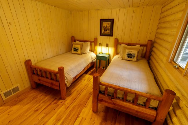 Bedroom featuring light wood-type flooring, wood walls, wooden ceiling, and log walls | Image 29