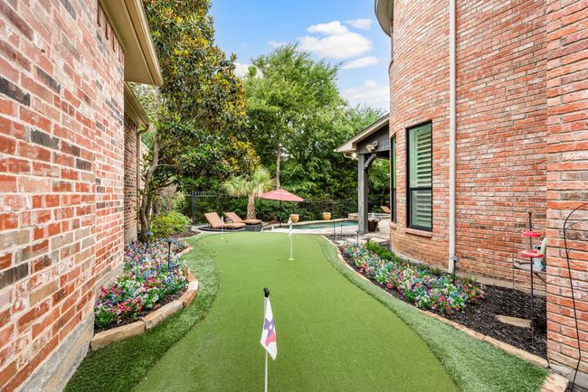 Side yard includes a two hole putting green. The side and rear yards are enclosed with an iron fence. | Image 33
