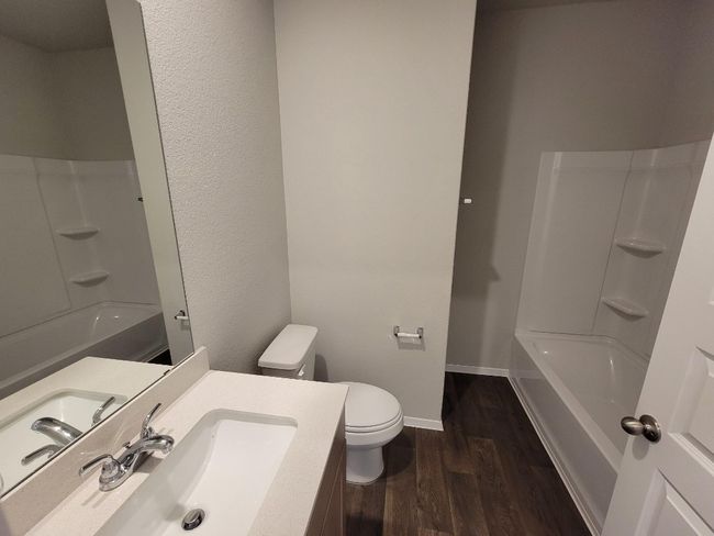 Bathroom featuring wood finished floors, vanity, and shower / bath combination | Image 12
