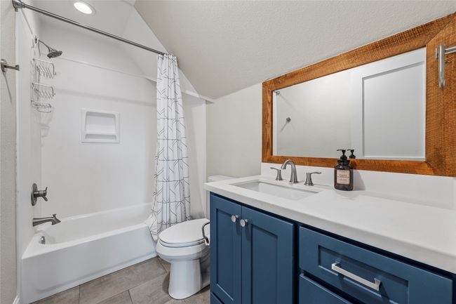 Full bath with vanity, toilet, shower / bath combo, lofted ceiling, and tile patterned floors | Image 19