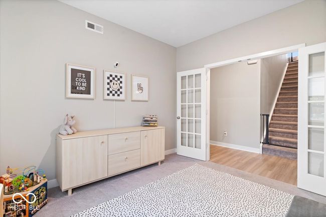 living area featuring french doors, stairs, and light colored carpet | Image 6