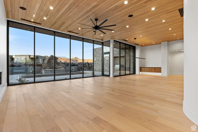Empty room with expansive windows, wooden ceiling, and wood-type flooring | Image 26